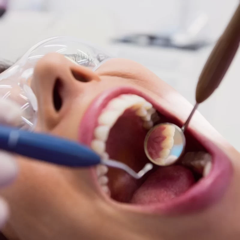 dentista-examinando-uma-paciente-sexo-feminino-com-ferramentas
